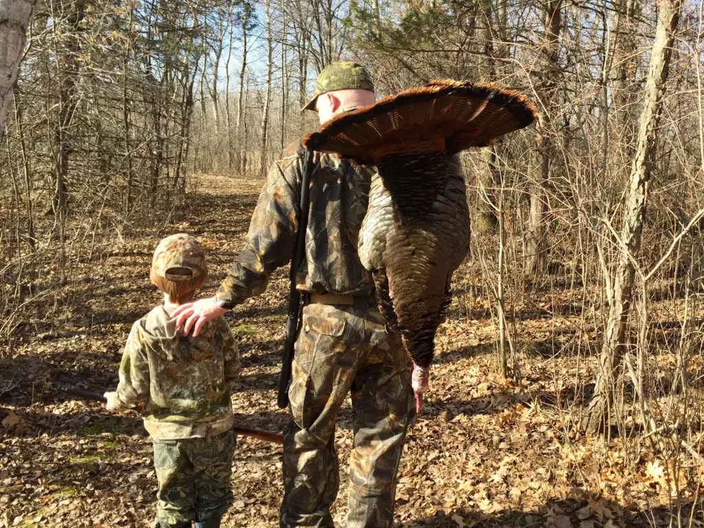 A hunter and son with a wild turkey