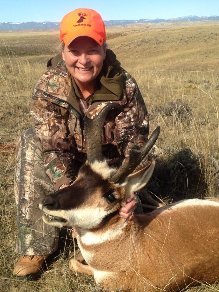 A female hunter holding an antelope