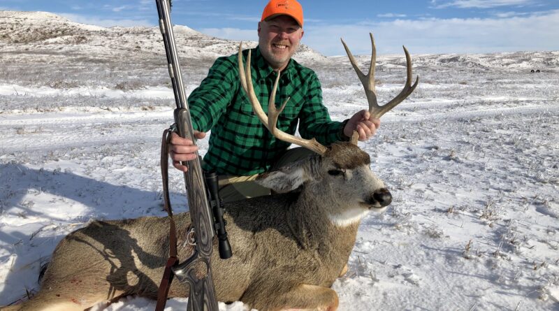 hunter with mule deer buck in Nebraska's Sandhills
